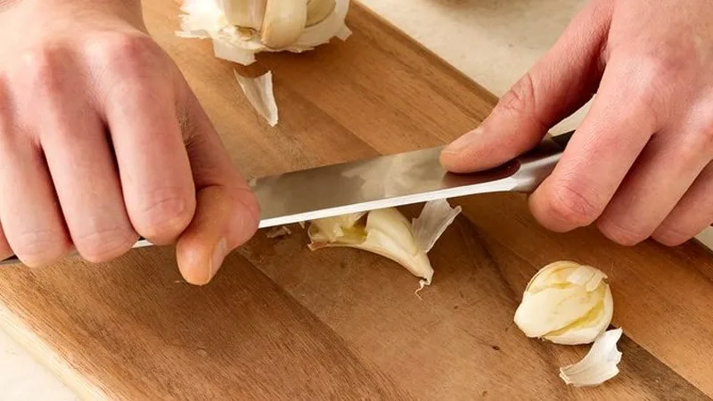 Dùng dao đập nhẹ là cách bóc tỏi nhanh, phù hợp khi chỉ cần vài tép để nấu ăn hằng ngày.