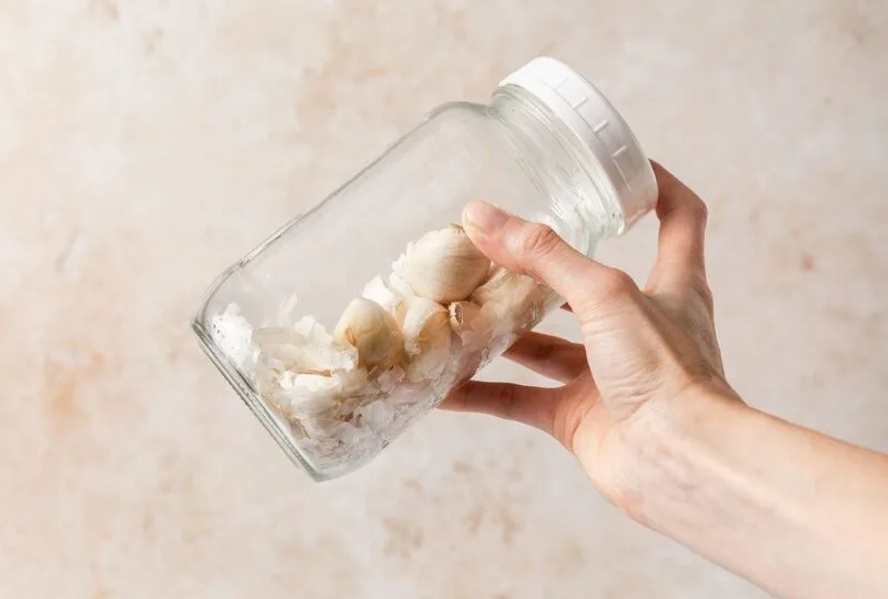 Lắc tỏi trong hộp kín giúp vỏ bong nhanh, phù hợp khi cần bóc nhiều tép cùng lúc.